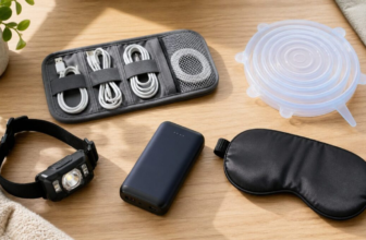 Useful everyday gadgets including cable organizer headlamp and portable charger flatlay on light wood