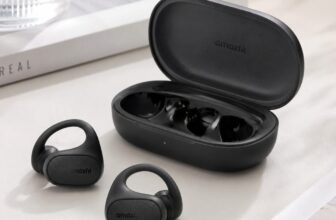 Amazfit Up open ear clip earbuds in black next to charging case on desk