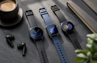 Three fitness smartwatches on a slate desk with earbuds and coffee
